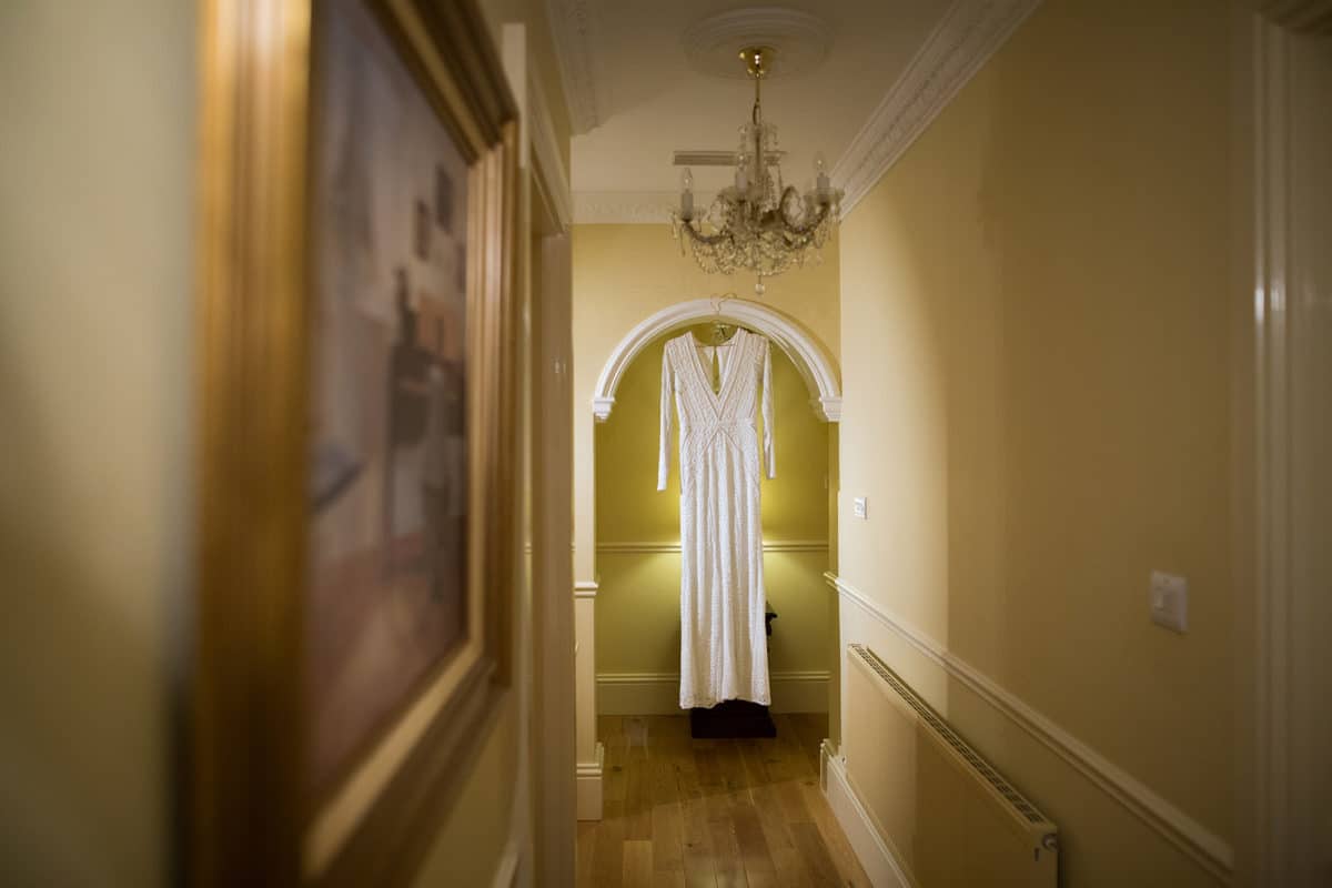 wedding dress hanging in hallway