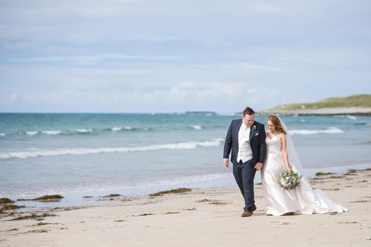 couple walking on the beach for wedding photos
