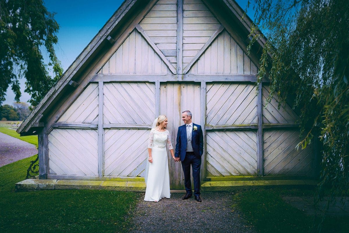 couple pose for wedding photos at a boathouse