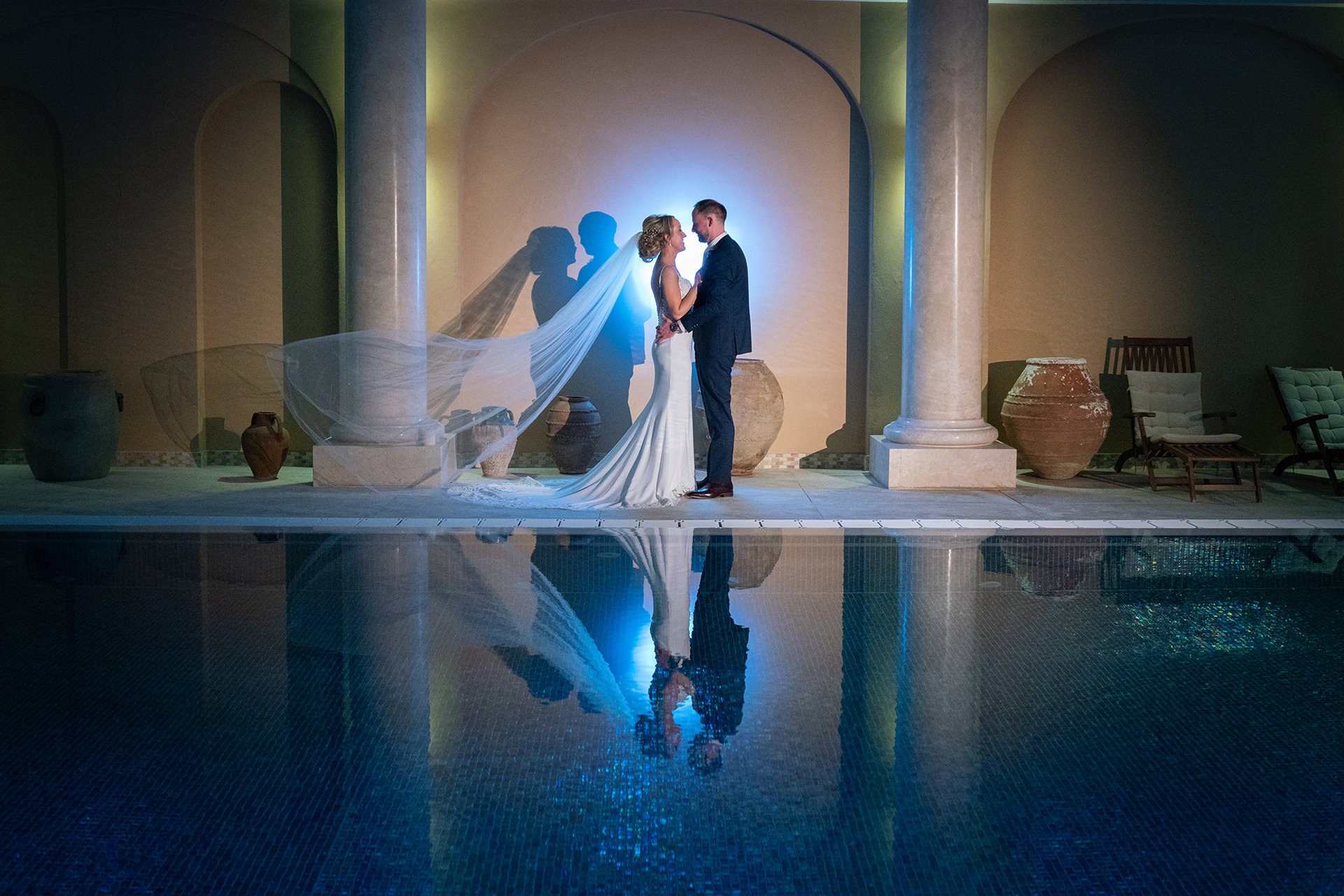 bride and groom pose for photos by pool